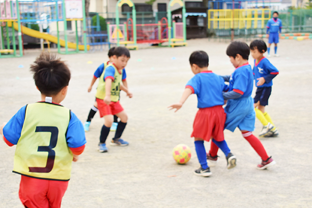 園庭でサッカーをする子どもたち